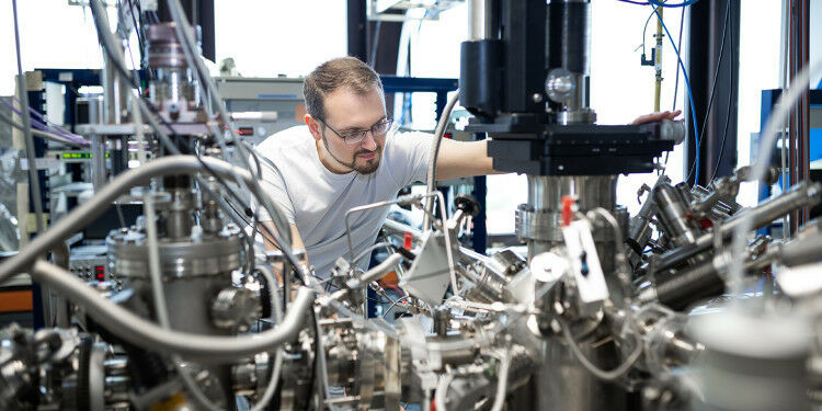 Fabian Schöttke im Physikalischen Institut an der Apparatur ROSE. Darin führt er