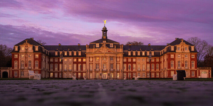 Das barocke Schloss der Universität Münster erstrahlt in der Abenddämmerung. © U