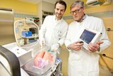 Norman Zinne (links) und   Axel Haverich an einem Organ Care System (OCS), das e