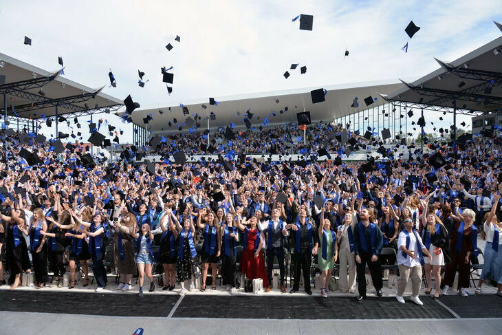 Graduierte werfen Hüte hoch