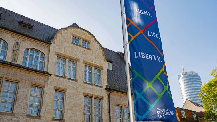 A flag bearing the motto »Light.Life.Liberty.« can be seen in front of the main
